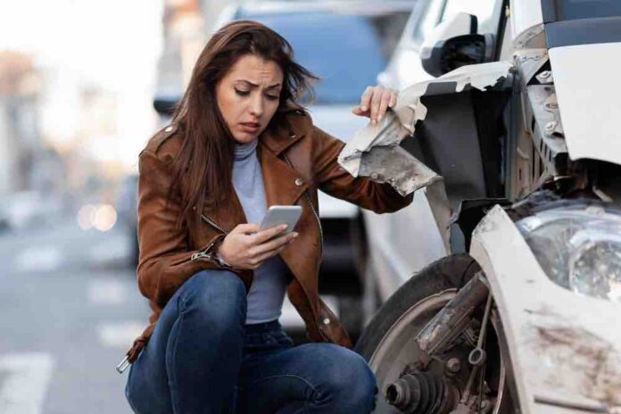 Woman Sittiing next to accidental car and calling Insurance